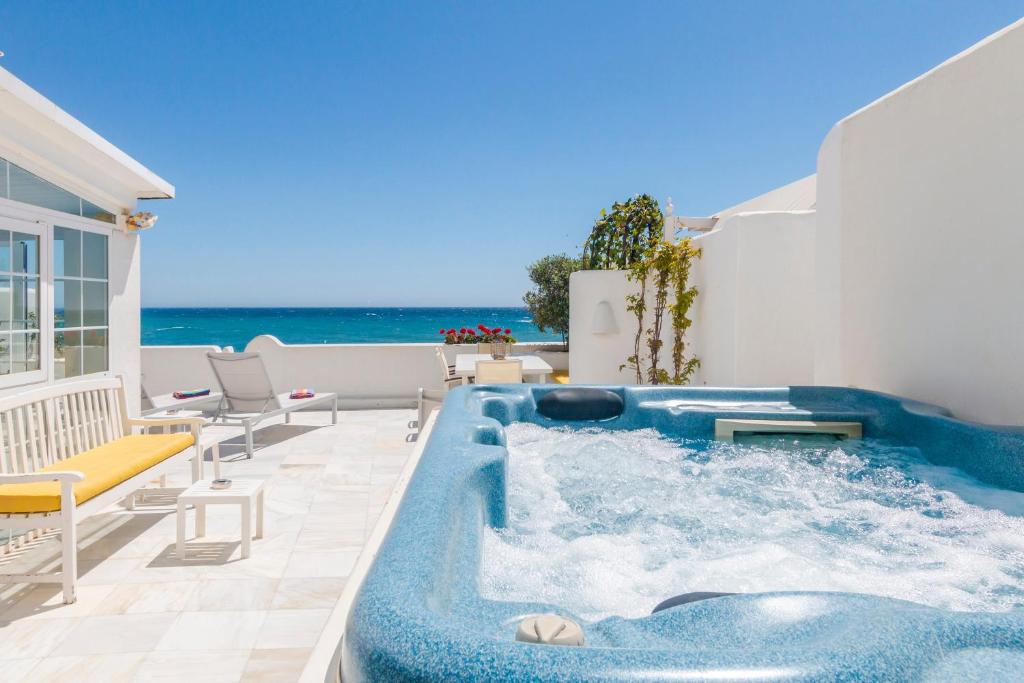 a pool on a patio with the ocean in the background at Deluxe Apartment with Jacuzzi in Marbella