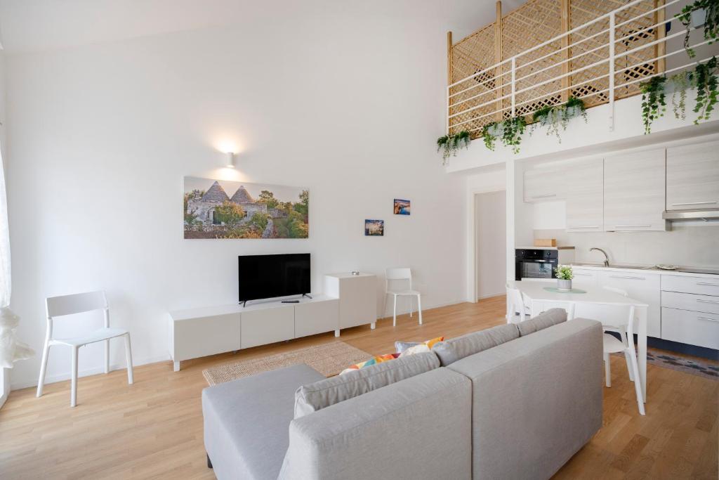 a white living room with a couch and a tv at Dimora Adriatica in Bari