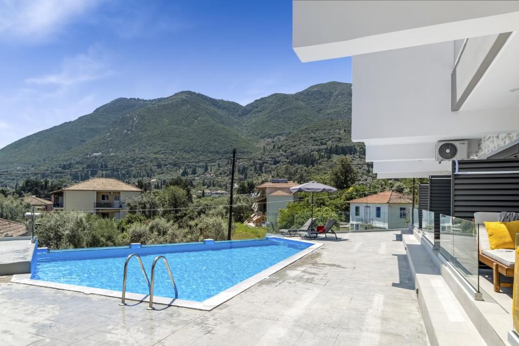 een villa met een zwembad en bergen op de achtergrond bij Oceanida Sofia Luxury Suite in Nikiana