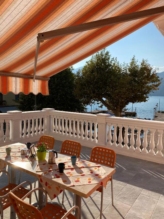 a patio with tables and chairs and a white fence at Casa Balansina Lake View in Brenzone sul Garda