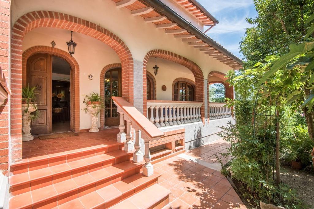 an exterior view of a house with a porch and stairs at Villa Vanna - Certaldo in Vico dʼElsa