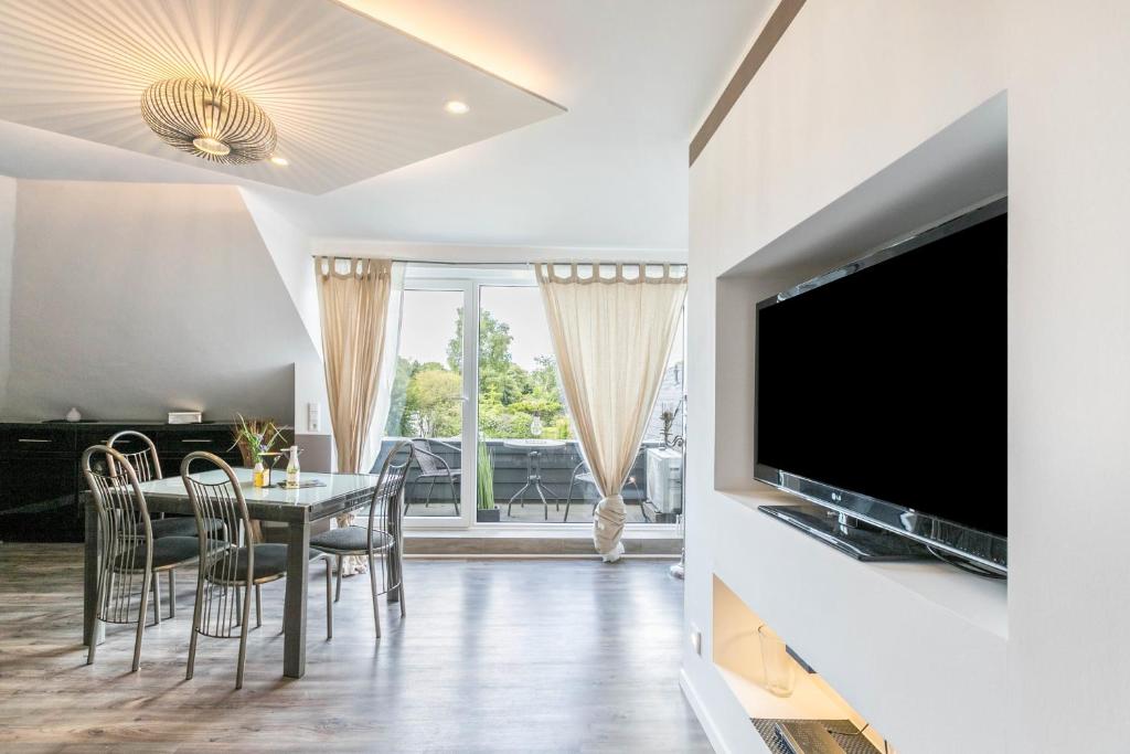 a dining room with a table and chairs and a tv at Uhse Wohlfühloase in Heide