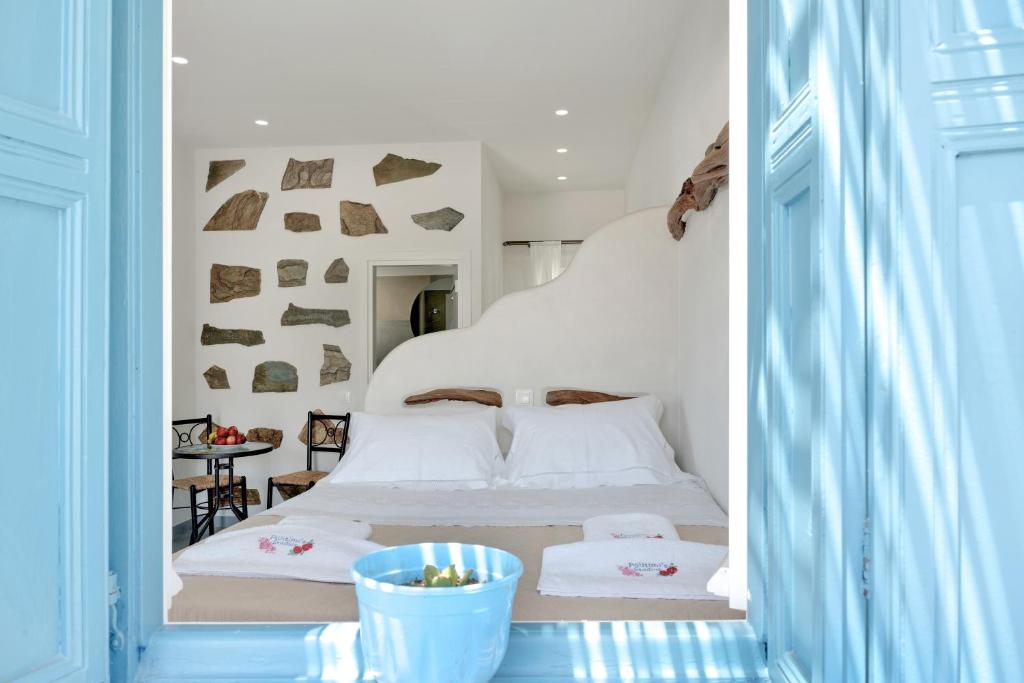 a bedroom with a white bed and a table at Politimis Studio N2 in Amorgos
