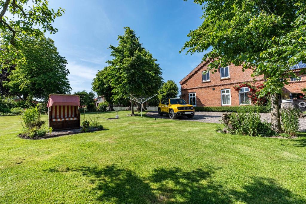 a yard with a yellow van parked in front of a house at Ferienwohnung Bauernhof Rohde in Gremersdorf