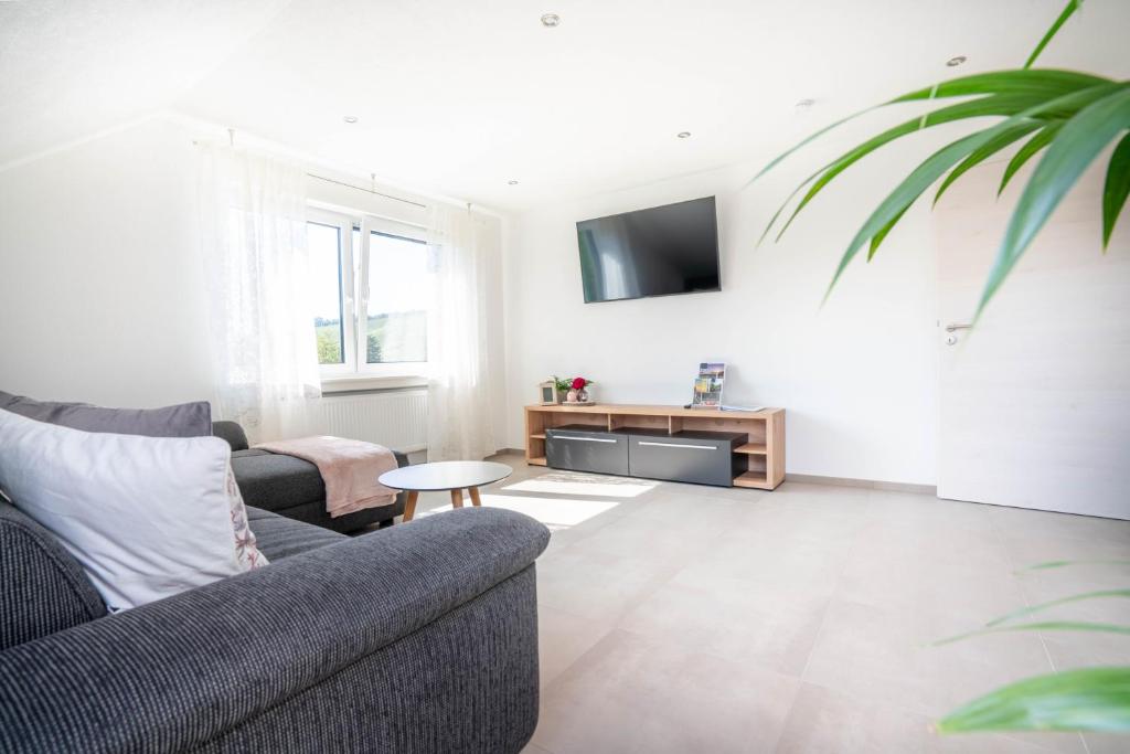 a living room with a couch and a tv at Ferienwohnung Weitblick in Durbach