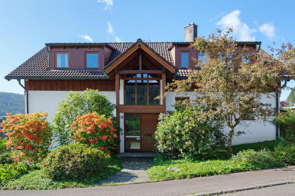 a house with a wooden door and some bushes at Ferienwohnung Sulzberg, 103qm in Alpirsbach