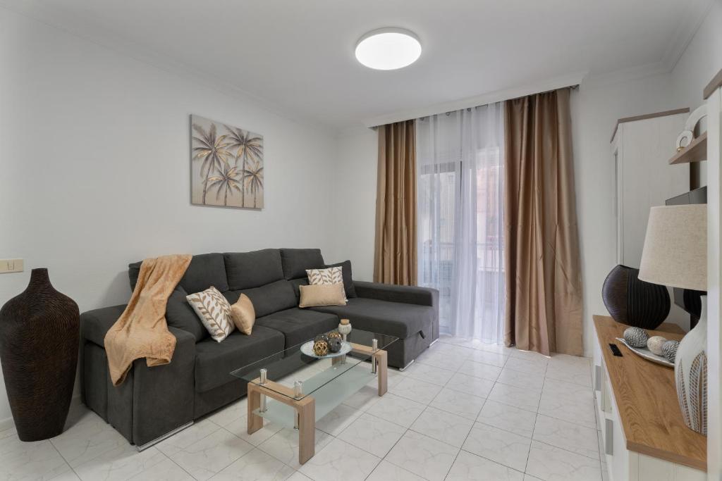 a living room with a black couch and a table at Apartamento Bonjour in Candelaria