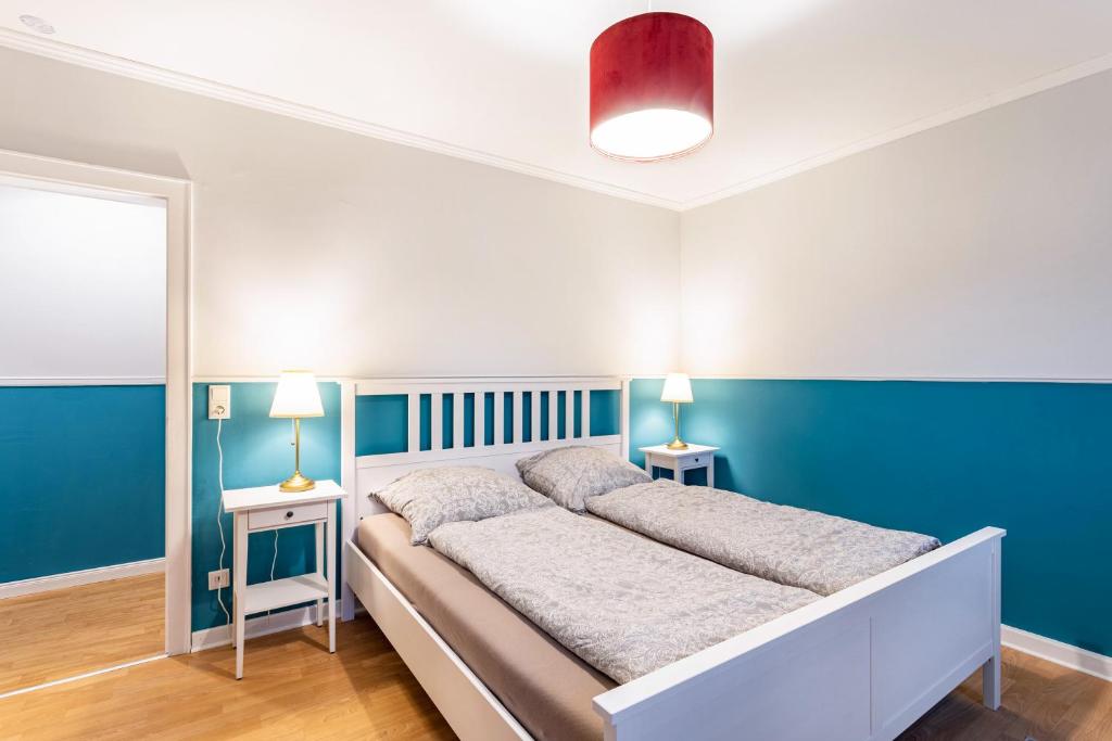 a bedroom with a large bed with blue walls at Ferienwohnung im Torwärterhäuschen in Rüthen