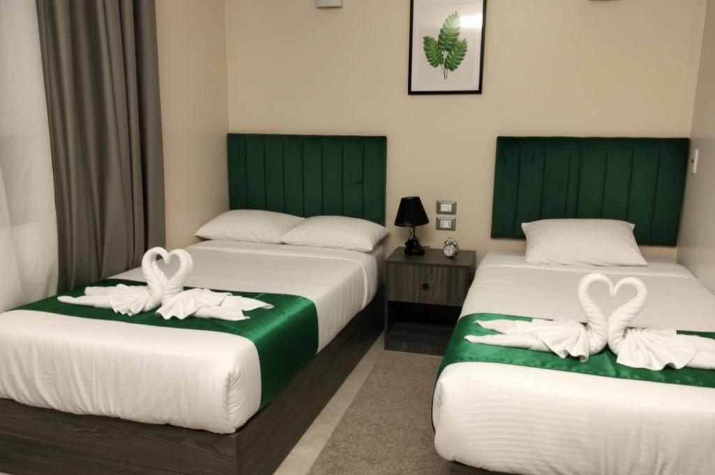 two beds in a hotel room with white towels on them at Cairo City Inn Hotel in Cairo