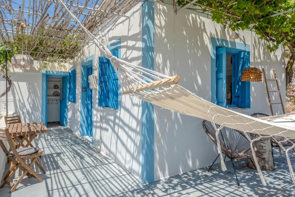 a hammock in front of a building with blue doors at Avlona Blue in Diafani