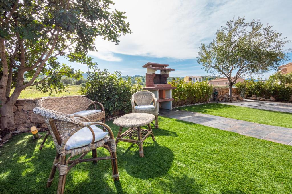 a group of chairs and a table in a yard at Casa a schiera Budoni in Budoni