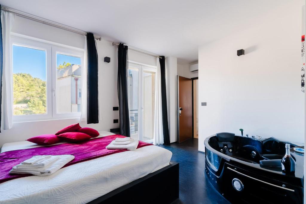 a bedroom with a large bed and a bath tub at Suite Black and White in Otranto