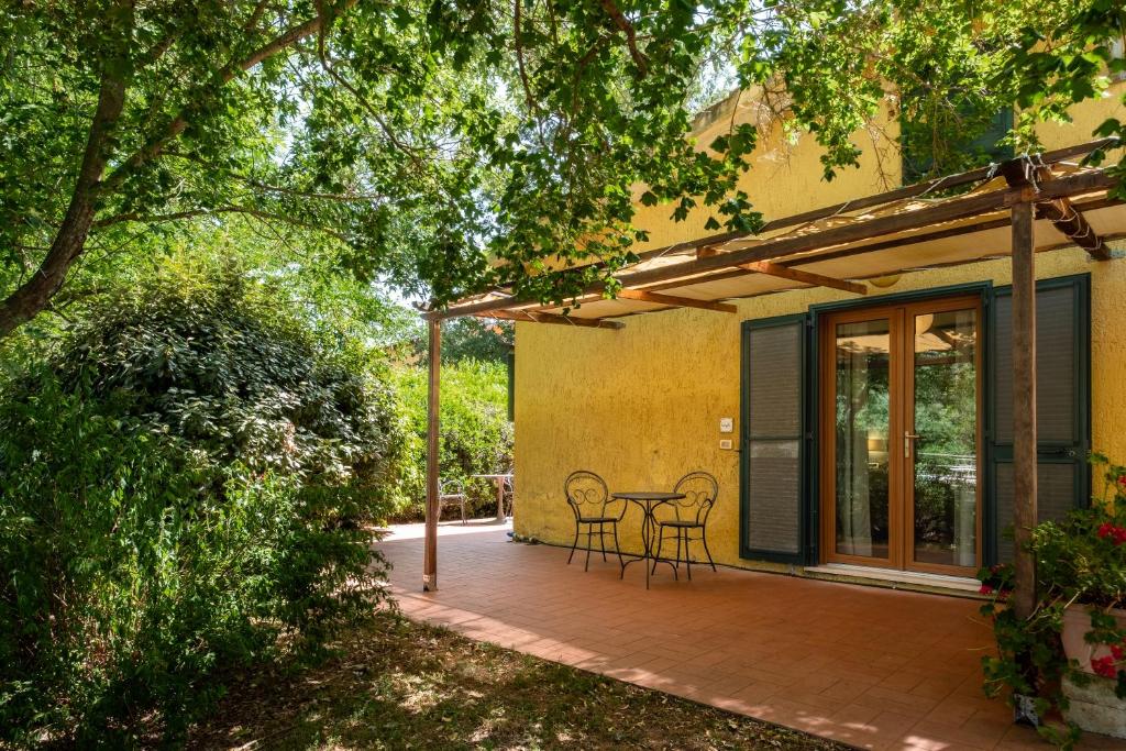 a patio with two chairs and a table at Rosaspina - Appartamento 7 in Capalbio