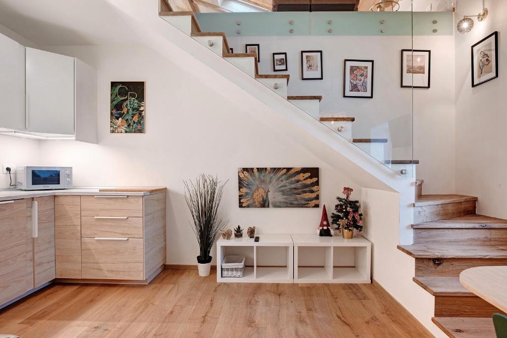 a kitchen and staircase with white walls and wooden floors at Wellness Lodge Chicca in Santa Giuliana