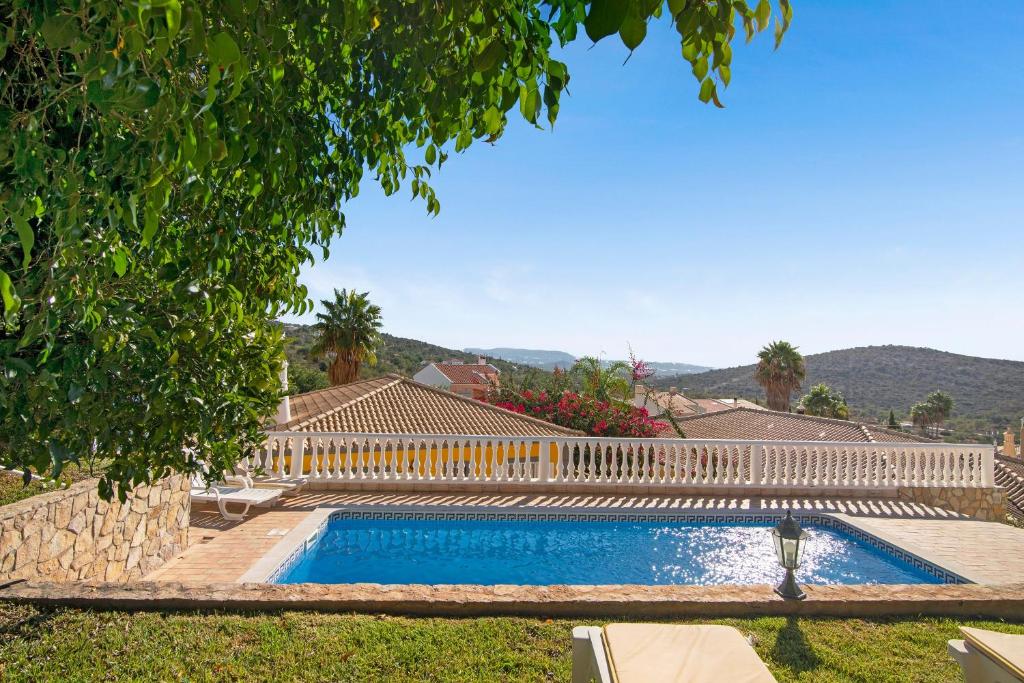 a swimming pool in a yard with a white fence at Villa Isabel in Loulé