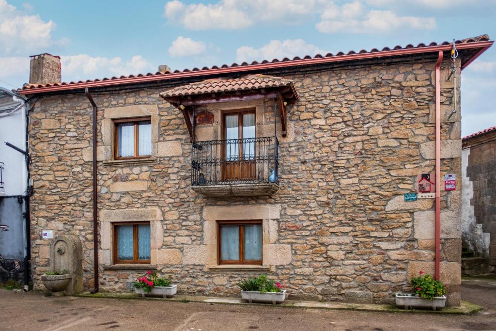 a stone building with a balcony on it at La Plazuela I in Pereña