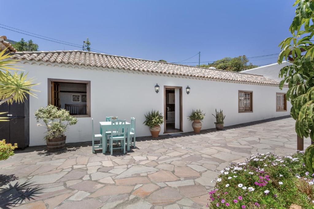 a white house with a patio and a table and chairs at Volcán 16 in Tanque