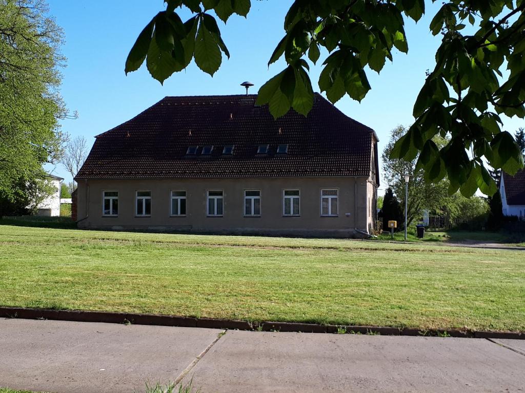 a large white building with a black roof at ehemaliges Gutsverwalterhaus in Mildenitz