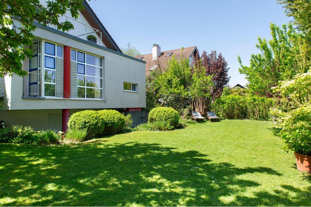 a house with a yard with green grass at Ferienwohnungen Riedel in Immenstaad am Bodensee