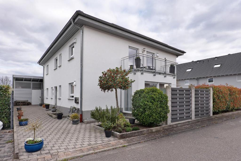 a white house with a courtyard with plants at Fewo Am Otterbach in Jockgrim