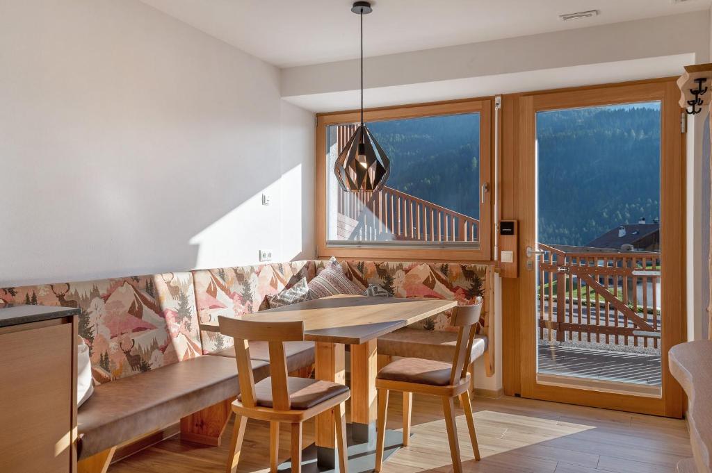 a dining room with a table and chairs and a balcony at Villa Solinda App Vivaldi in Selva