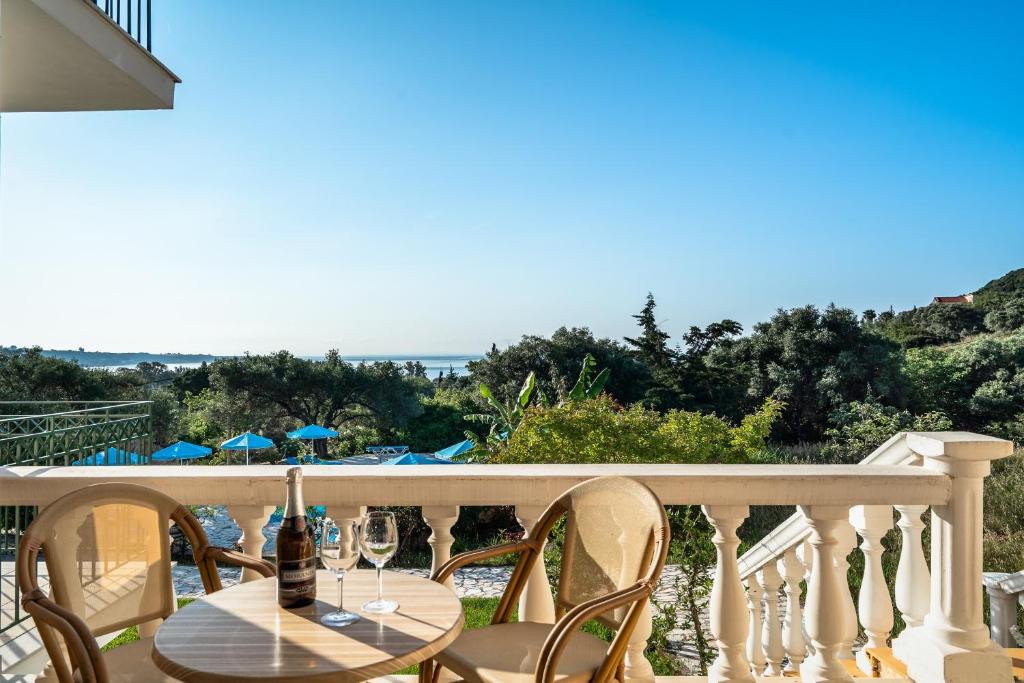 a table and chairs on a balcony with a view of the ocean at Anemona studio E in Kefallonia