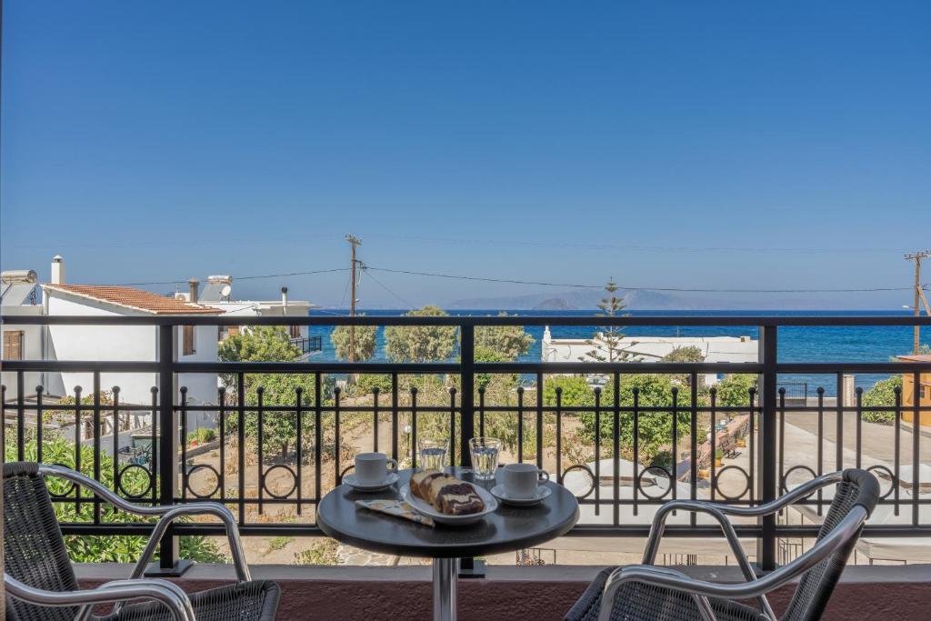 a table and chairs on a balcony with a view of the ocean at Frantzis studio 4 in Páloi