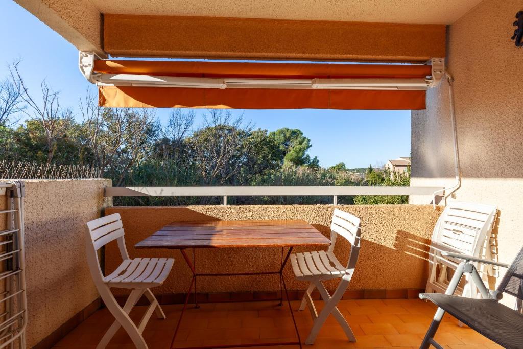 a wooden table and chairs on a balcony at Studio Sanary in Sanary-sur-Mer