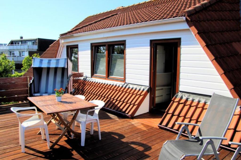 a deck with a table and chairs on a house at Olde Toornblick in Borkum
