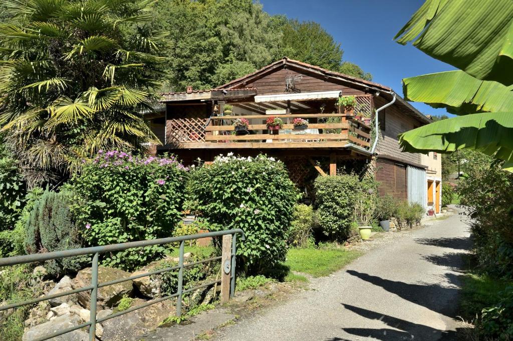 a house with a balcony with plants on it at Au Fil De L'eau in Chein-Dessus