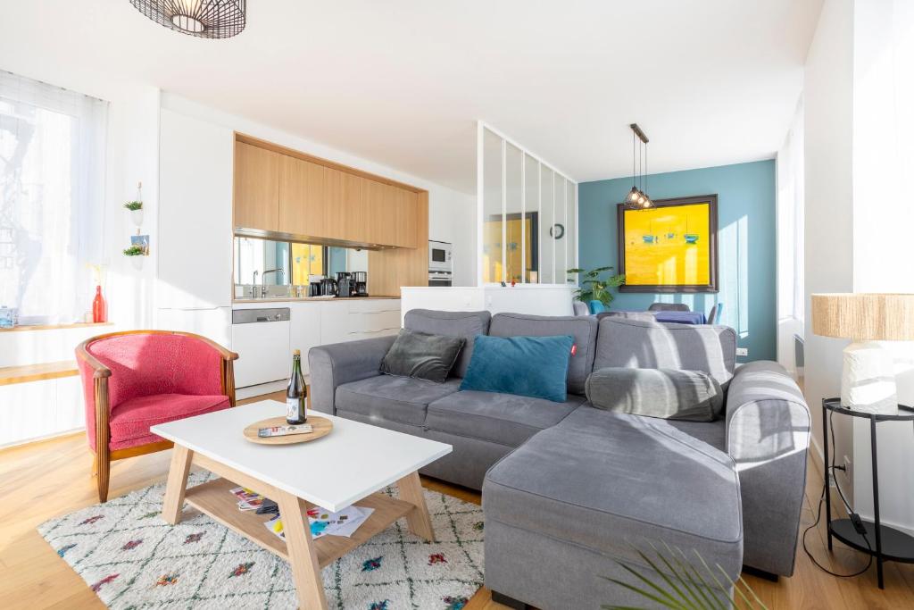 a living room with a gray couch and a table at Le Pied-à-terre in Bénodet