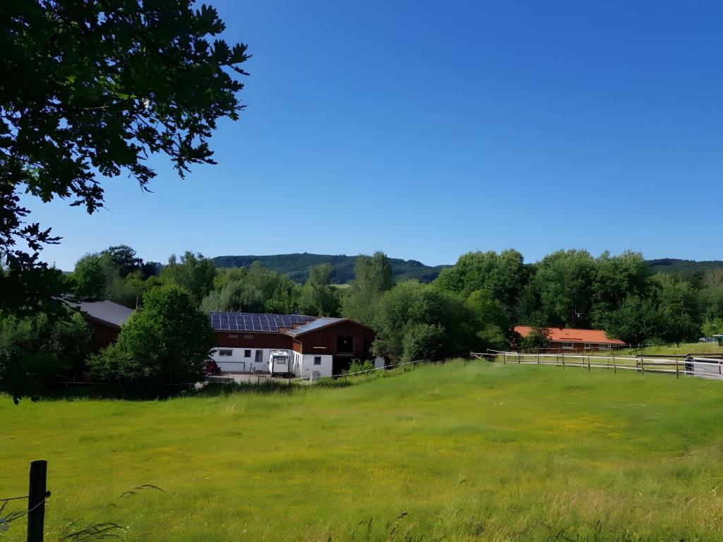 a large grassy field with a house and a barn at Urlaub Auf Der Aspen Ranch in Salem