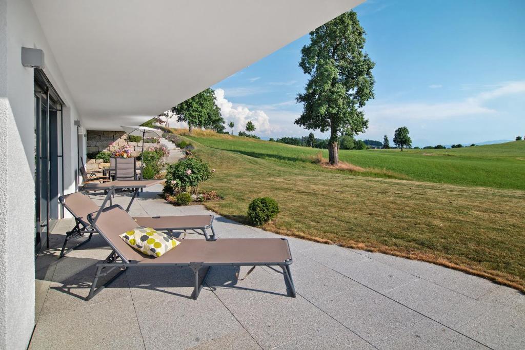 a group of benches sitting on a porch with a field at Fewo Landschaftstraum am Bodensee in Lindau