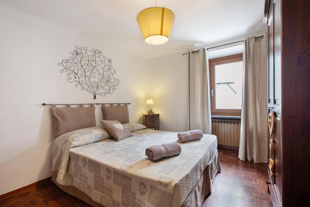 a bedroom with a bed with two pillows on it at Appartamento Delfine in La Salle