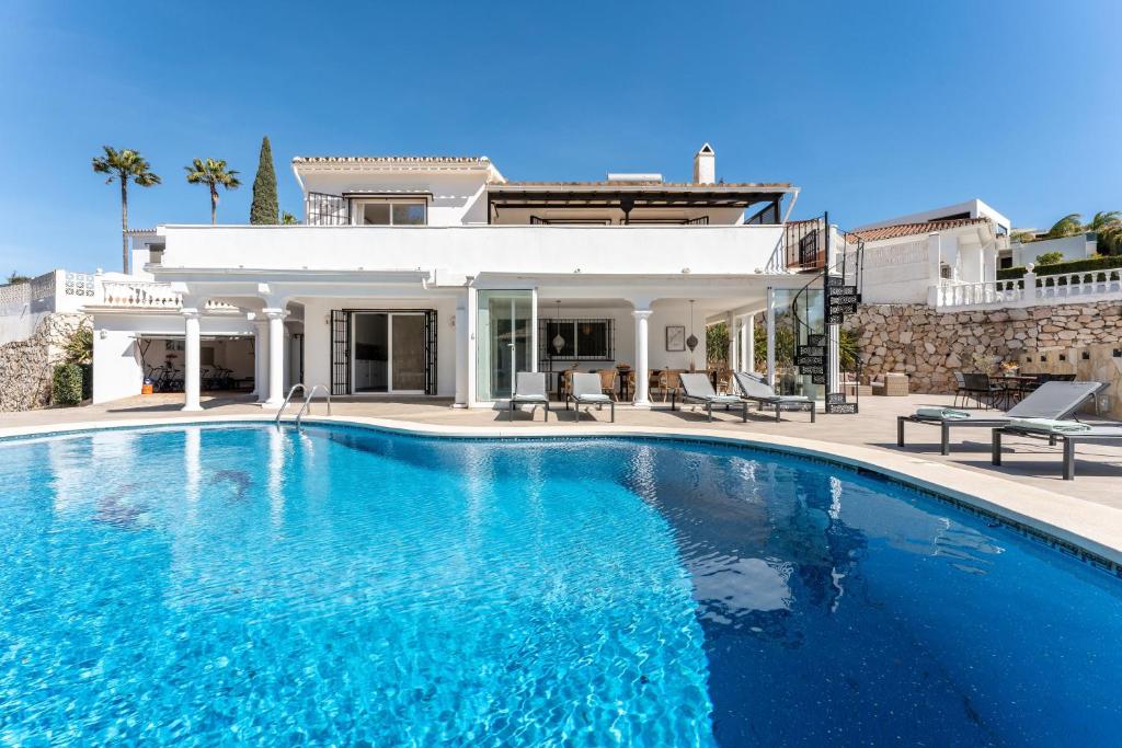 a large swimming pool in front of a house at Holiday Villa Torrenueva in La Cala de Mijas