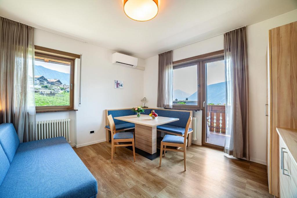 a room with a table and chairs and a window at Gartenheim App Martin in Schenna