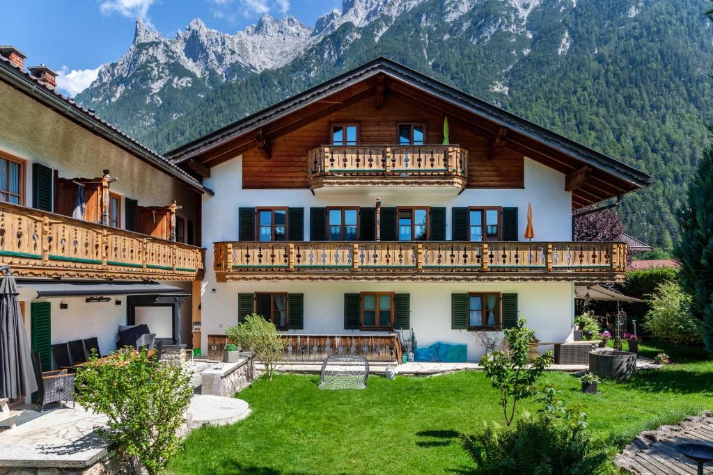 a house with a balcony and mountains in the background at Ferienhaus St Christoph in Mittenwald