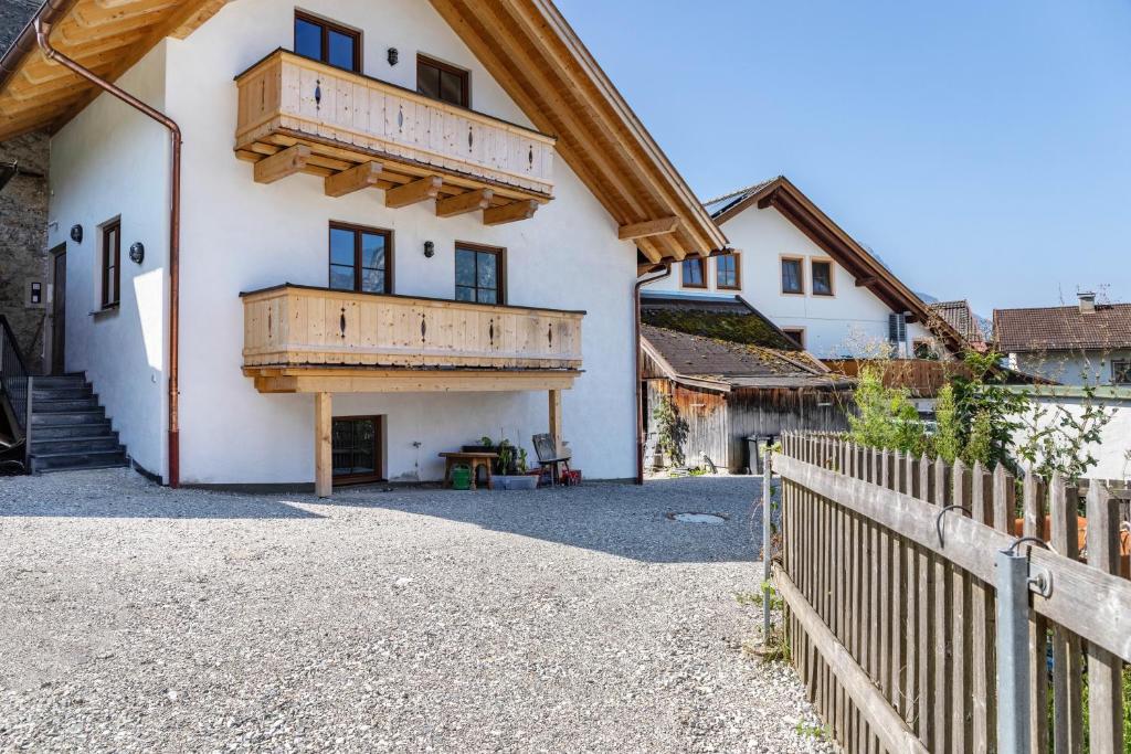 a house with a balcony and a wooden fence at Beim Schweizer in Garmisch-Partenkirchen