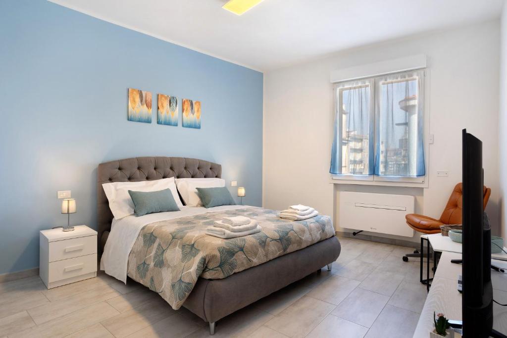 a bedroom with a bed and a desk and a television at Suite Ponte Vecchio in Pavia