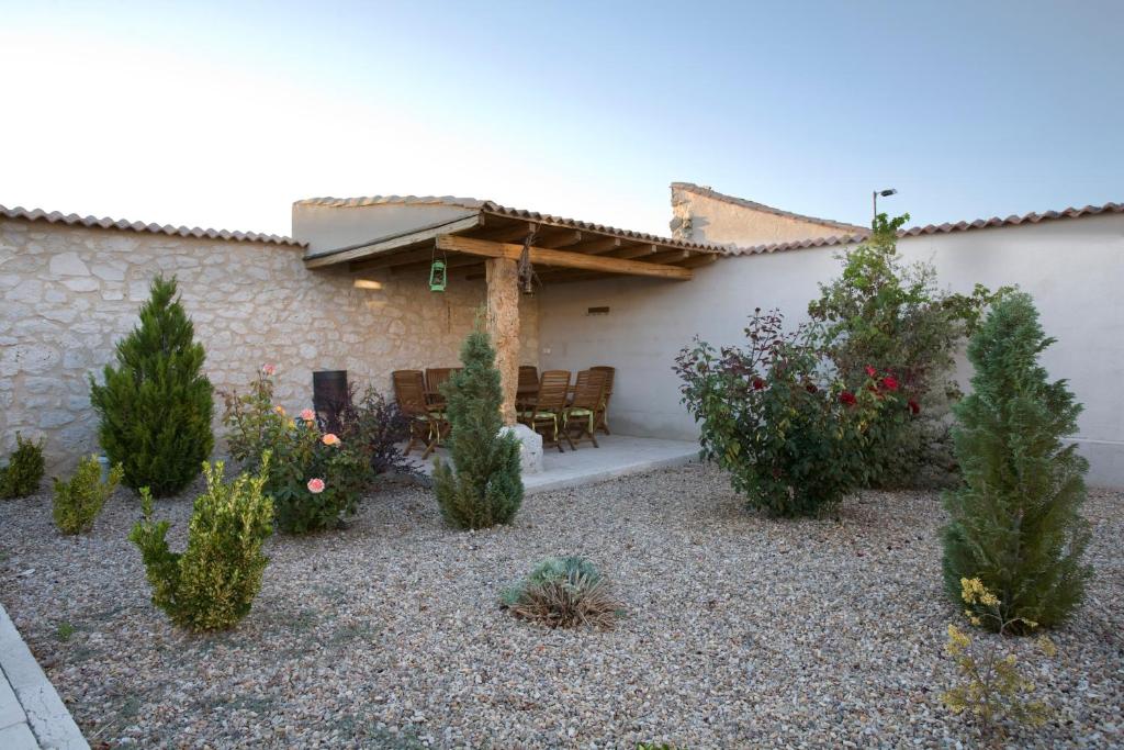 ein Garten mit Bäumen und Pflanzen vor einem Gebäude in der Unterkunft Las Espigas in Canalejas de Peñafiel