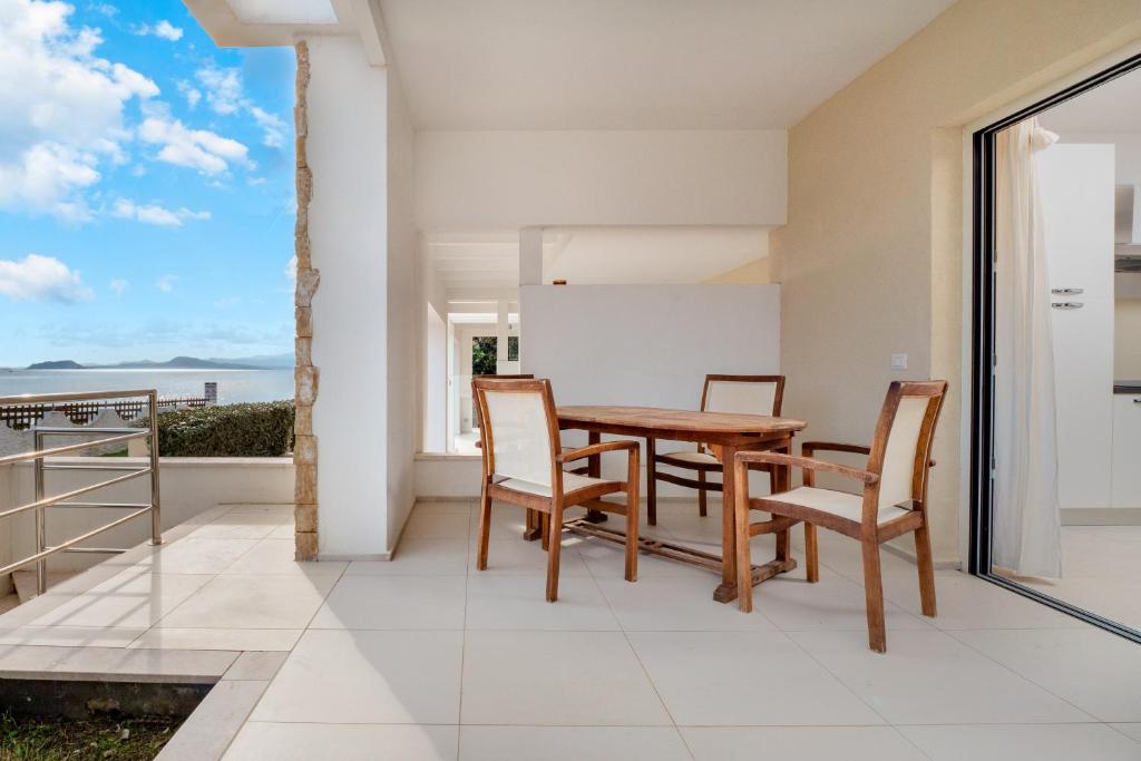 a dining room with a table and chairs on a balcony at Cormorani - Appartamento 3 in Golfo Aranci