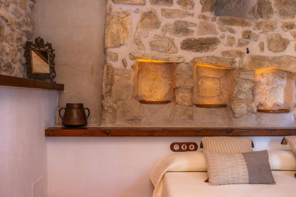 a stone wall with three jars on a shelf at Ses Solls in Petra