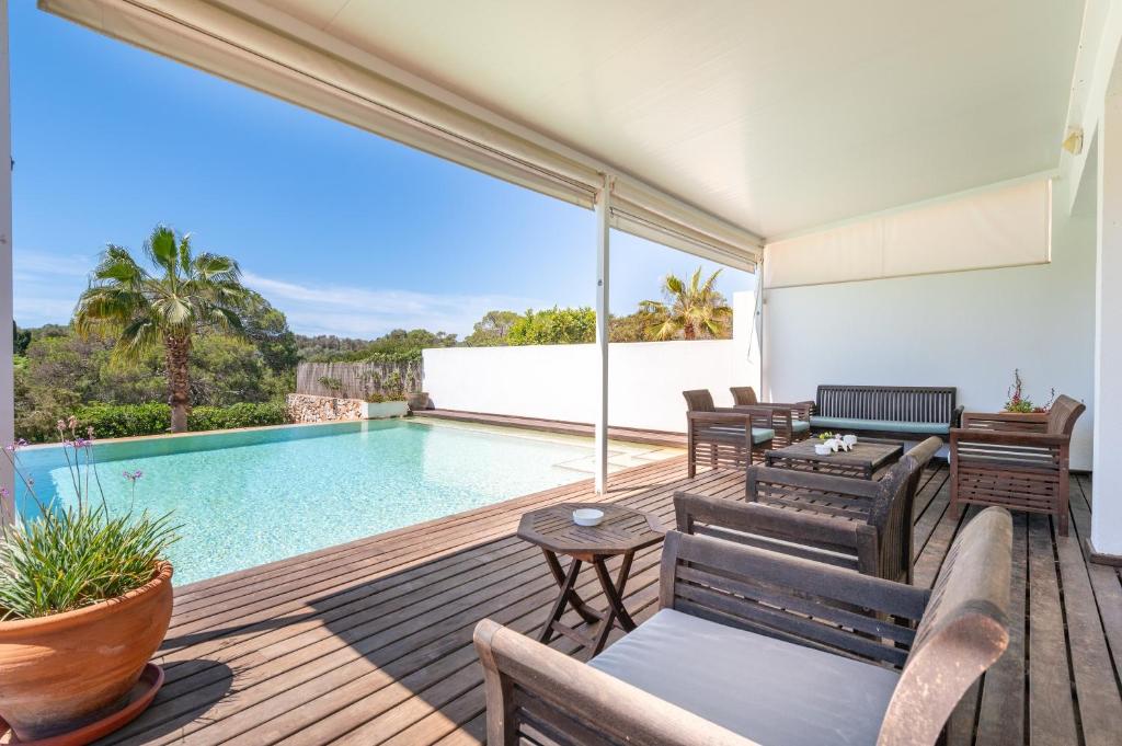 a patio with a swimming pool and a deck with furniture at Casa La Siesta in Cala d´Or