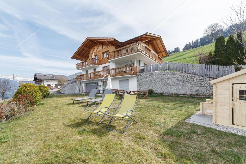 a house with a table and chairs in the yard at Ederhof in Schenna