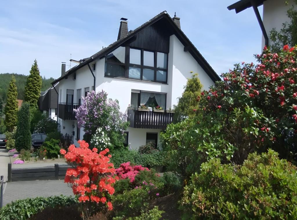 a white house with flowers in front of it at Apartment Neuenrade in Neuenrade