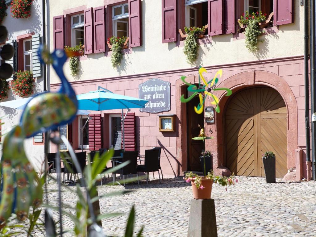 a building with an entrance to a restaurant with an umbrella at Schmiede Burkheim in Vogtsburg