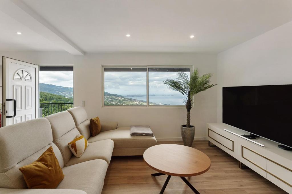 a living room with a couch and a flat screen tv at Casa Belavista in Gaula
