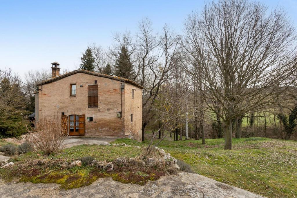 an old brick house in a field with trees at Cal Cisteller in Olvan