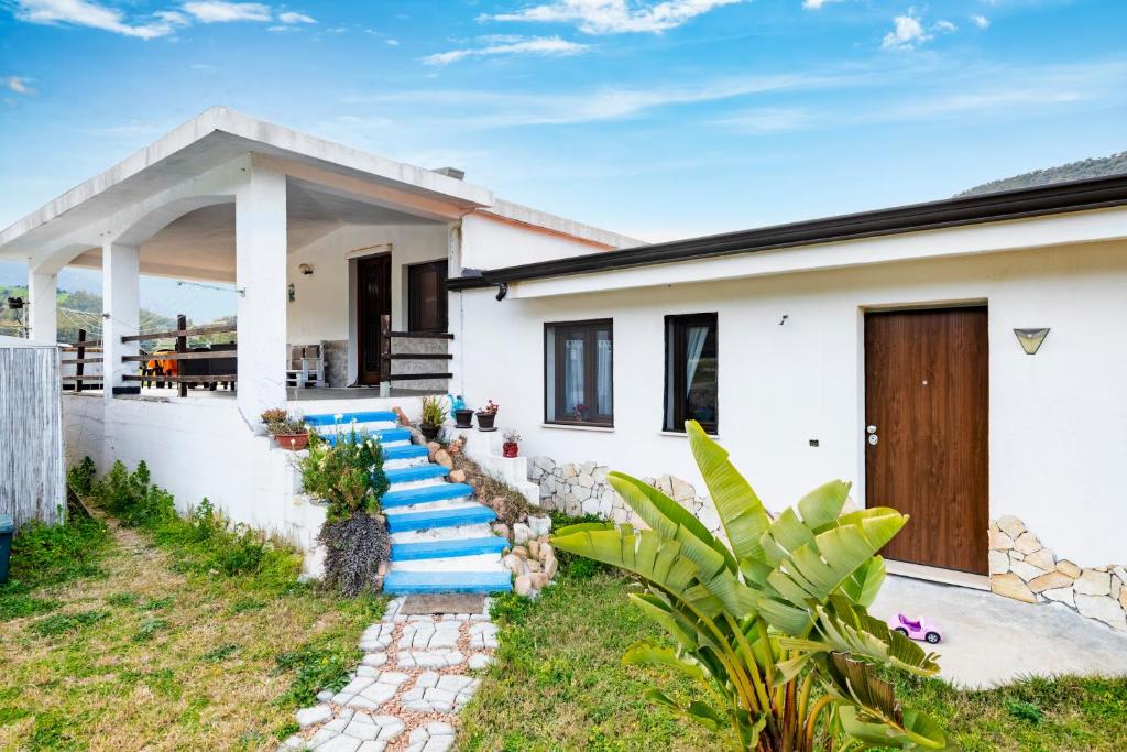 a house with a staircase leading to the front yard at Casa I Ginepri in Cardedu