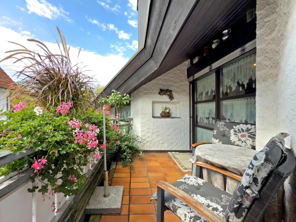 a patio with flowers and a table and chairs at Ferienwohnung Schindele in Langenargen